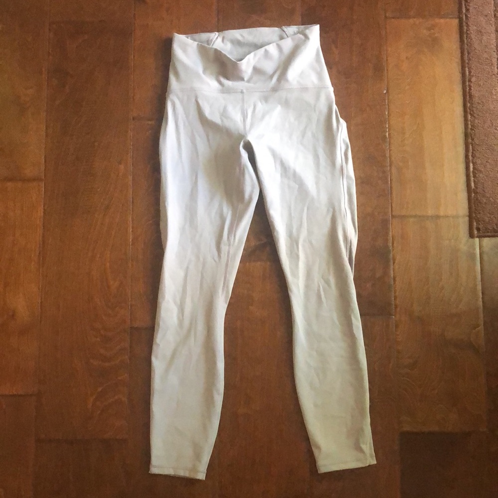 Taupe grey Lululemon capri leggings with mesh accents on the side of the legs